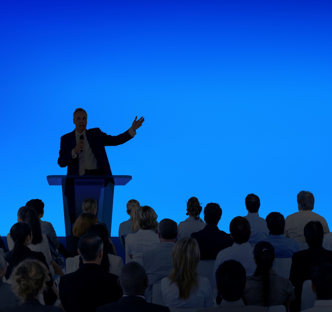 Corporate businessman giving a presentation to a large audience